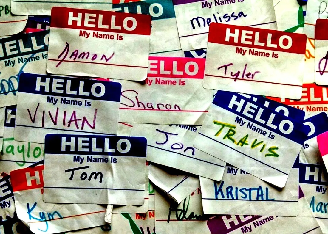 Dozens of “Hello, my name is” stickers piled up, with first names written in marker: Damon, Vivian, Tom, Travis.
